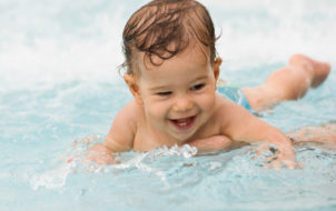 Smiling baby boy during a swimming lesson in a pool