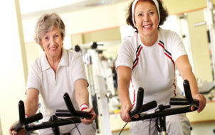 Portrait of two senior women on simulators looking at camera and smiling; Shutterstock ID 85664767; PO: aol; Job: production; Client: drone